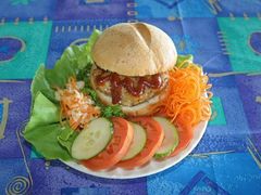 plate of burger and greens, cucumber and tomato