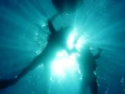 Light shining on swimmers in the Blue Cave