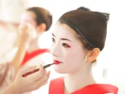 Putting on maiko white make up and lipstick