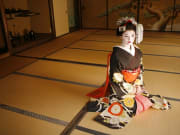 Costumed maiko kneeling on tatami mats