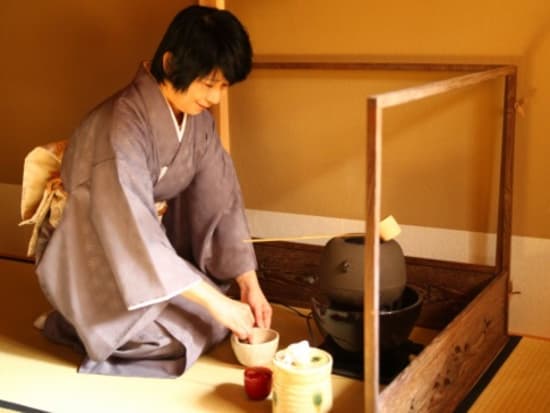 A tea instructor whisking matcha green tea