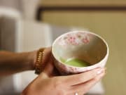 Matcha tea in a cherry blossom patterned cup