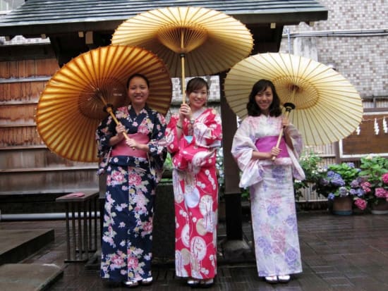 3 women wearing yukata, holding Japanese umbrellas