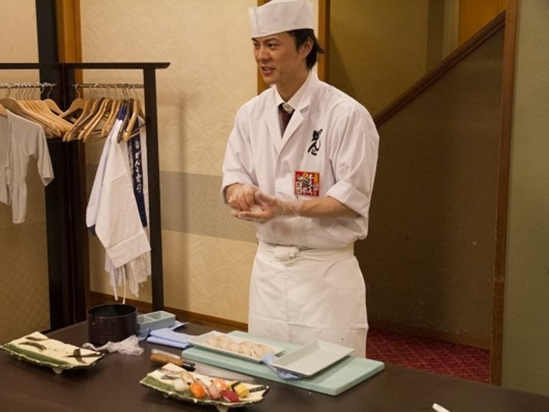 Sushi chef demonstrating how to make sushi
