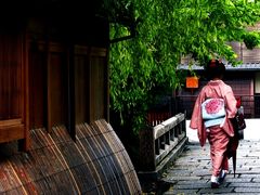 A kimono wearing woman walking in Gion