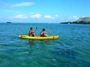Two people paddling a sea kayak in Okinawa