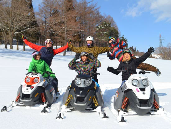 Riding snowmobiles over fresh snow in Japan