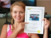 woman holding certificate after skydiving
