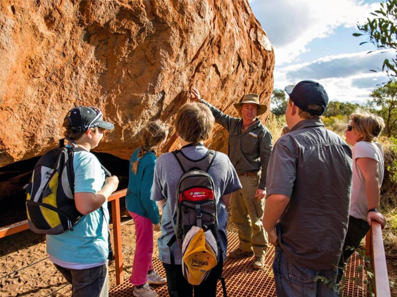 guide explaining about uluru to tourists