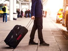 man carrying luggage to board shuttle service