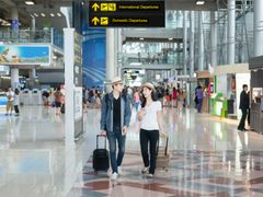 couple with matching straw hat walking at airport
