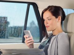 Woman looking at her phone in the car