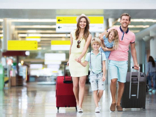 Family walking in the airport with luggage