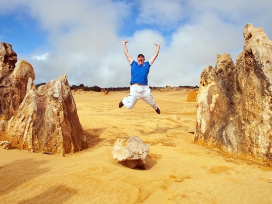 man mid-air jump at pinnacles desert australia
