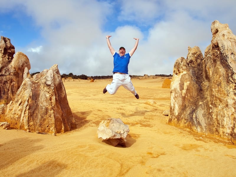 man mid-air jump at pinnacles desert australia