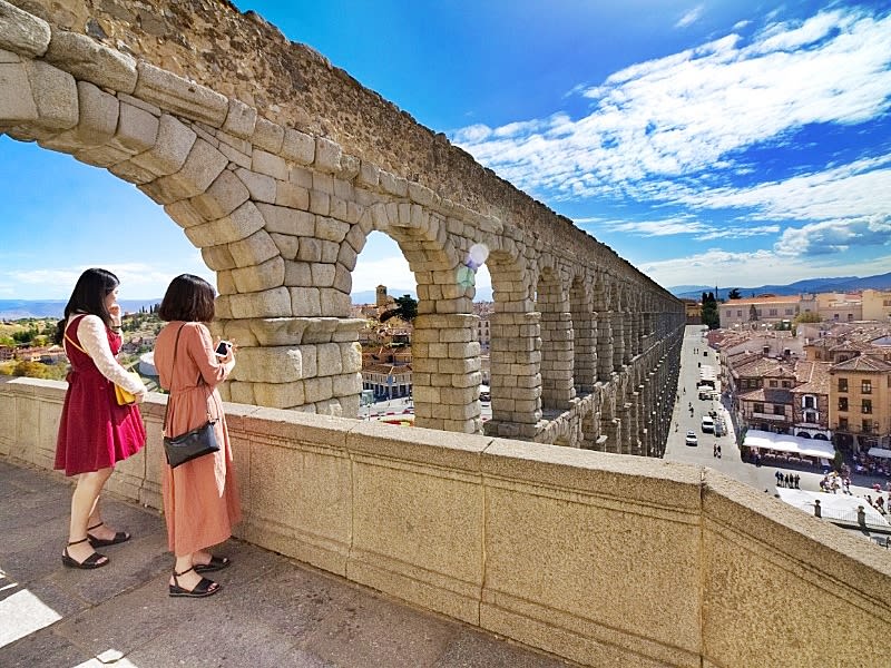 Tourists on looking at the Aqueduct of Segovia
