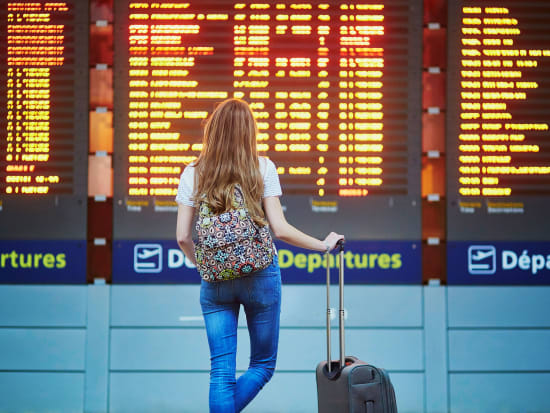 airport woman looking at flight schedule