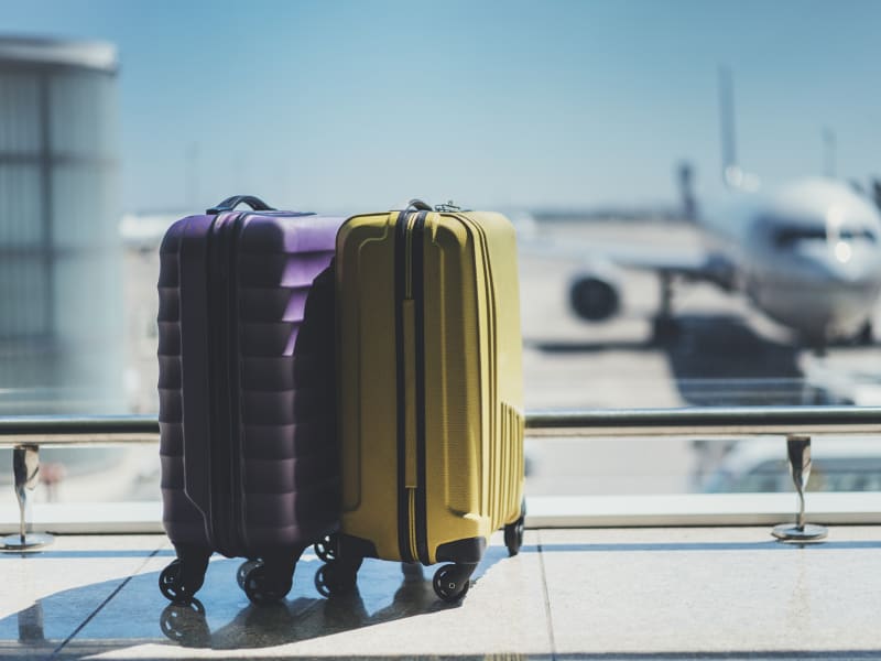 yellow purple suitcases airplane on background