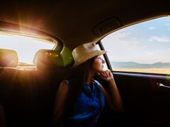 woman sitting inside car looking at outside view
