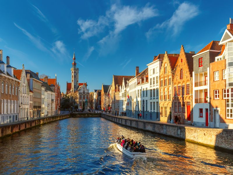 Belgium_Bruges_canal_Spiegelrei_and_Jan_Van_Eyck_Square_Morning_Boat_shutterstock_384744043