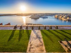 Beautiful sunrise at the famous saluting battery of Valletta with Grand Harbor and Senglea and Brigu at background. Blue sky and