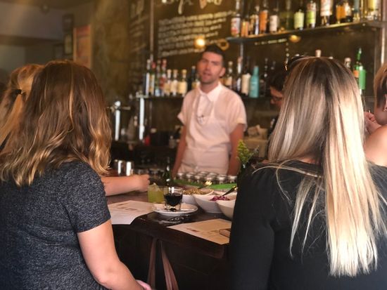 Avital Ungar. East Village Food Tour. Guests listening to chef jonah Miller at Huertas for hands on culinary activity
