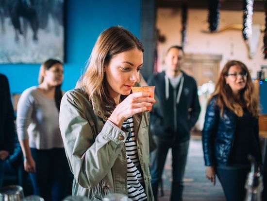 Brooke Porter. Mission District Food Tour. Guest smelling and sipping cocktail at west of pecos mixology