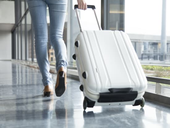 A woman walking with suit case_pixta_68137158_M