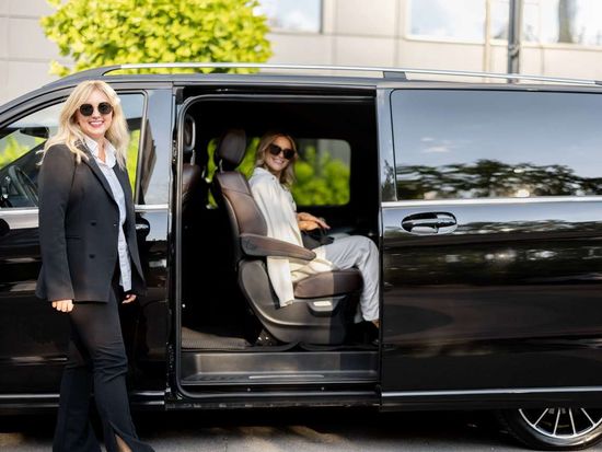 female-chauffeur-helps-a-business-people-to-get-ou-2023-11-27-05-11-41-utc