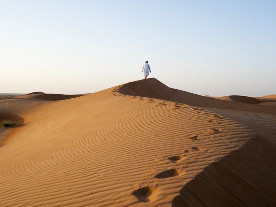 Omani man walking in Dunes,Oman cSultanat_d_Oaman