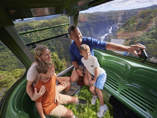 Skyrail Rainforest Cableway family in Diamond View Gondola with Barron Falls in view